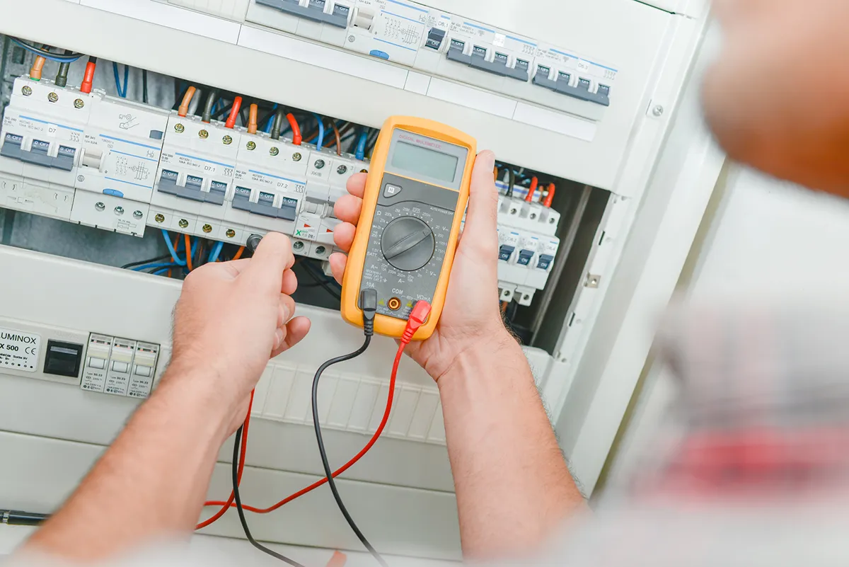 Electrician testing a switchboard with a multimeter